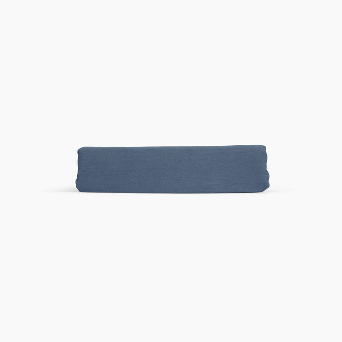 Avec linen fitted sheet in harbor folded neatly on a white background