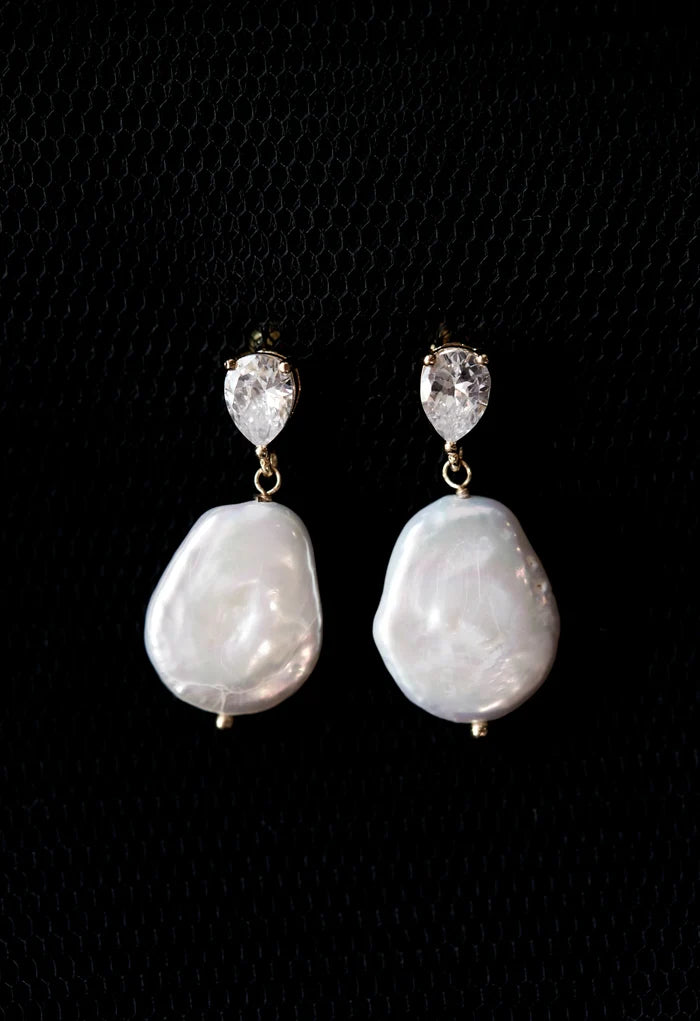 Pearl earrings with crystal tops on a black background