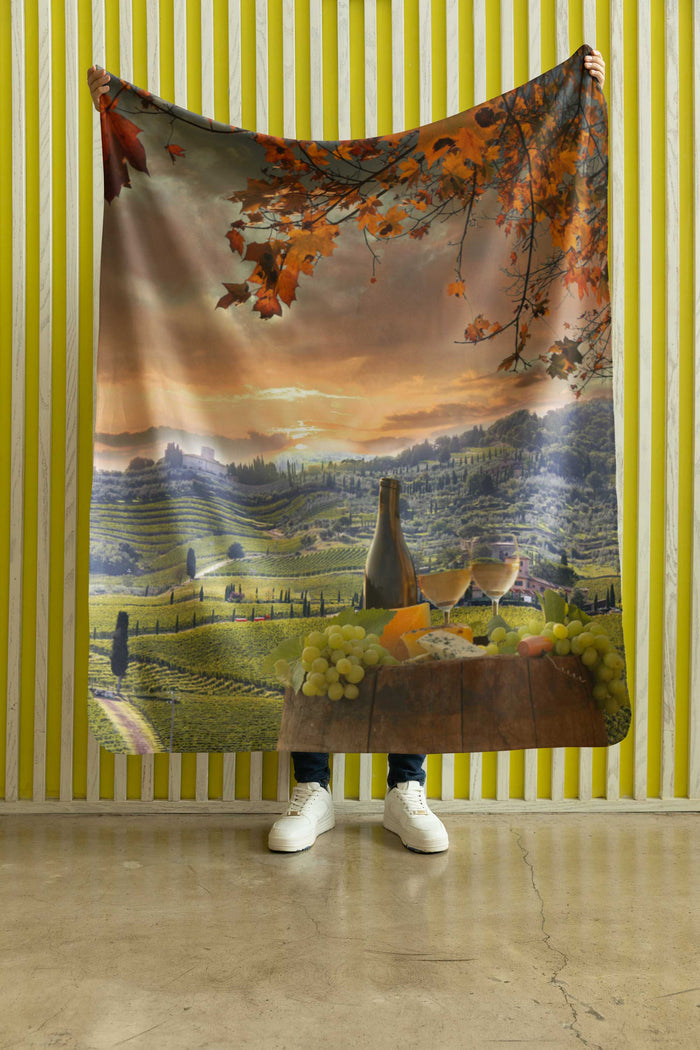 Person holding a Chianti, Tuscany tapestry with a landscape design against a yellow striped wall.