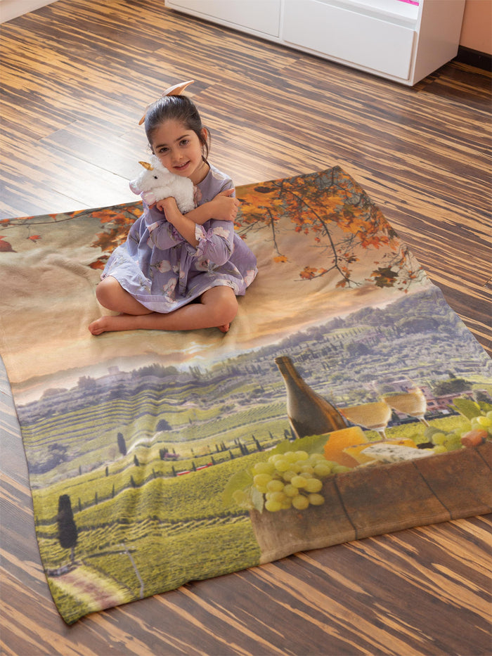 Child sitting on a rug with a scenic design in Chianti, Tuscany, holding a toy sheep.