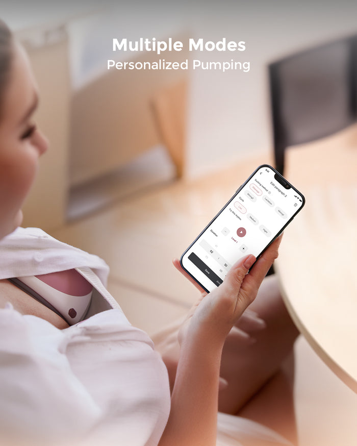 A women wearing Momcozy Mobile Flow™ electric hands-free breast pumps uses a smartphone app to control the pumps.