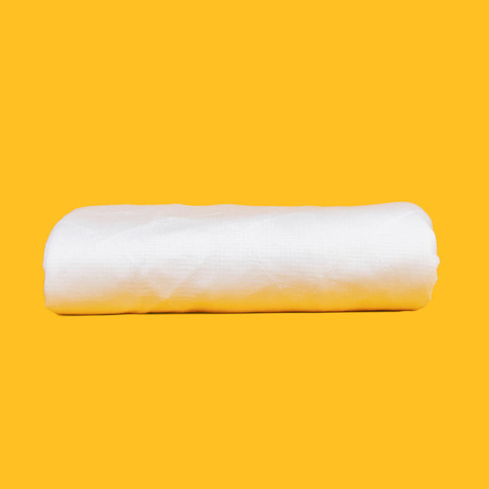 A folded Slumber Cloud Performance Mattress Protector on a yellow background.