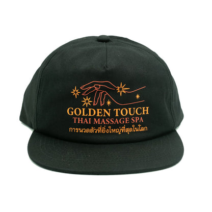 A black unstructured cap with a text logo on the front that reads 'Golden Touch Thai Massage Spa' in orange and white.