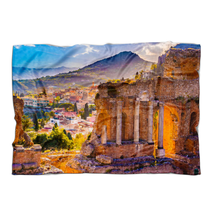 A fleece blanket with a print of an Italian cityscape, featuring a white underside and finished edges to prevent fraying.